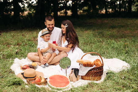Picture of cheerful young caucasian female and male holds their child on hands, smiles and rejoicesの写真素材