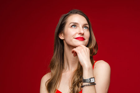 Pensive beautiful woman with hand at chin.
