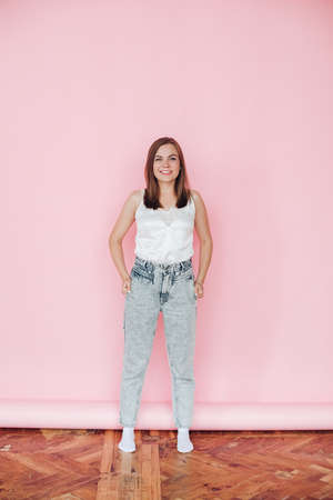 Handsome girl in summer clothes rejoices, picture isolated on pink backgroundの写真素材