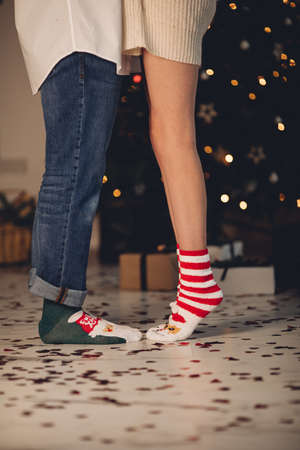 Unrecognizable woman tiptoes to kiss standing on floor with confetti.の写真素材