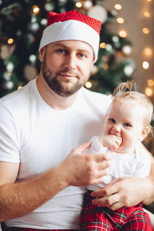 Father in Santa hat with daughter.