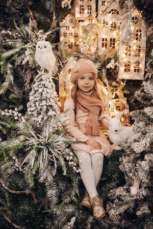 pretty caucasian female child poses for the camera in a beautiful christmas decorationの写真素材