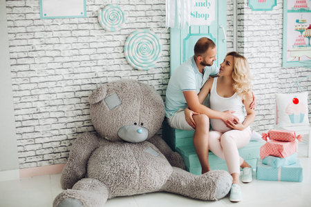 Parents sitting on stairs and embracing stomach.