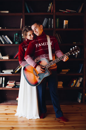 Couple playing on gitar and embracing.
