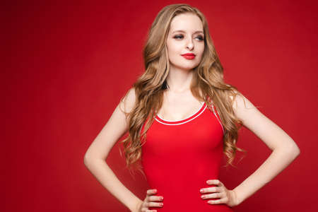 Beautiful female model posing on red backgroundの写真素材