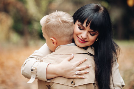 Mom and son are on good terms, walking in the park, chatting. Stylish family, family look