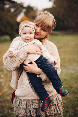 Beautiful caucasian mother with braid embracing her daughter.の写真素材