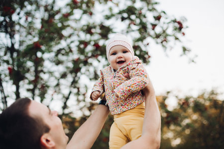 Father and daughter walking in the park in autumn, portrait. Dad and daughter, family concept. A...