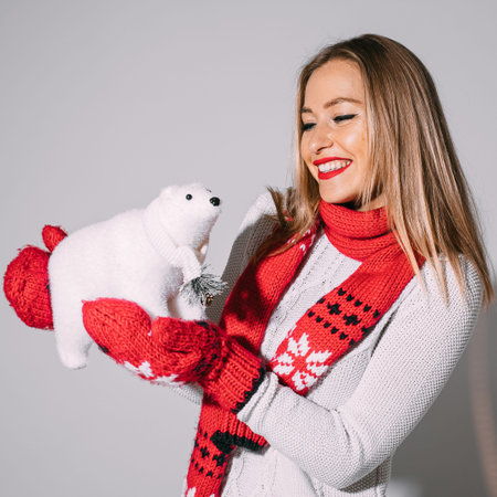 Joyful blonde woman posing with toy polar bear