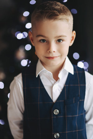 A handsome boy in a stylish outfit smiles, looks at the camera, poses