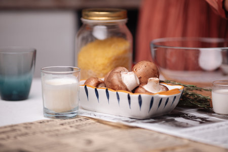 kitchen, a woman cooks, food and plates on the tableの写真素材