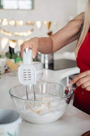 Womens hands prepare the cream using a mixer