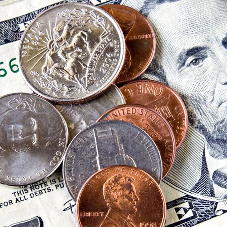Coins laying on a five dollar bill ( quarter, nickel, dime, penny )の写真素材
