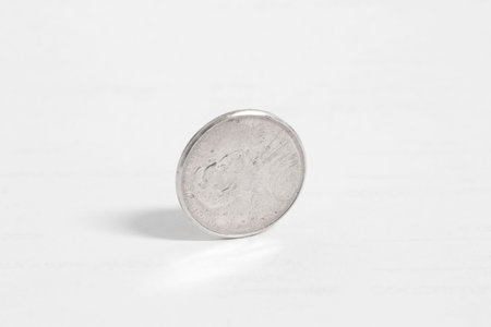 Old nickel standing on edge on white paperの写真素材