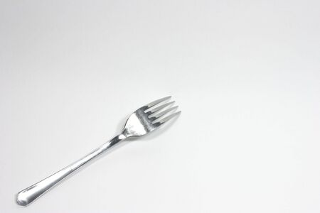 Dinner serving fork in corner on white backgroundの写真素材