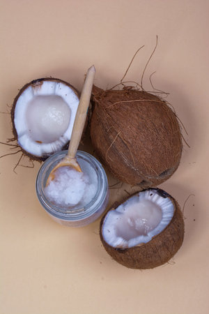 Coconut with coconut oil on a cream background, coconut oil