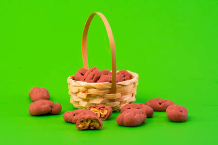 Pecan in white chocolate on a green background. Packaging, chromakey, advertising of nuts in chocolate. Nuts in a basket.の写真素材