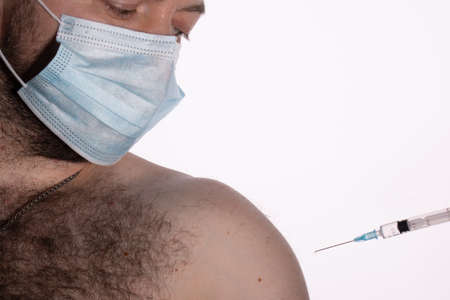 A doctor in medical gloves vaccinates against Covid-19, or the flu, to a patient with an antiviral injectionの写真素材