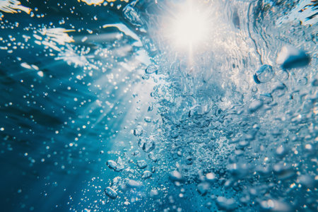 Bubbles ascend from below, capturing sunlight that dances on the water's surface. The scene breathes tranquility and beauty, highlighting the mesmerizing interplay of light and liquid.の素材