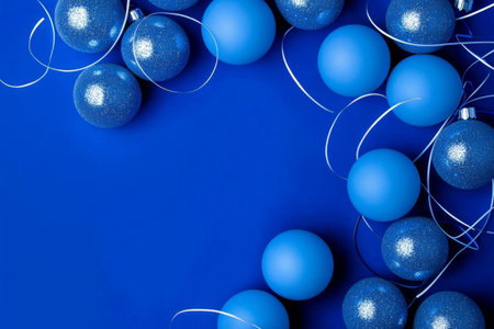 Blue decorative ornaments arranged on a vibrant background for festive occasionsの素材