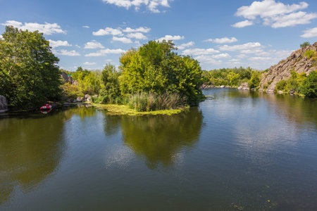 Landscape on the Mihia River. The river is surrounded by trees and herbs. Reeds grow in the river. Ukraine, Pervomaisk.の写真素材
