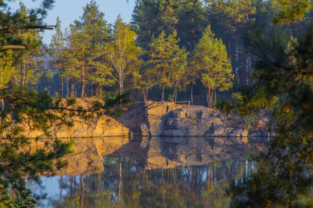 A steep bank of a beautiful quarry with clean water. Tall stone. Ukraine.の写真素材