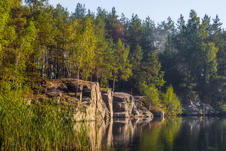 A steep bank of a beautiful quarry with clean water. Tall stone. Ukraine.の写真素材