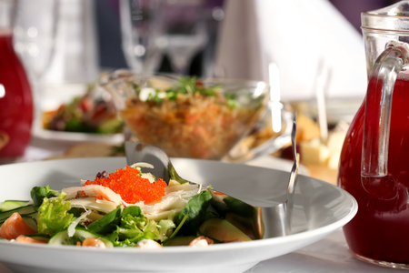 Salad of seafood, red caviar, cucumber and sorrel on a white plate. Restaurant dietary useful tasty food.の写真素材