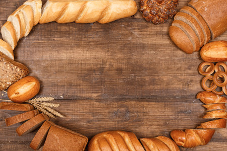 Bread of different kinds on the table copy space. Baking of dough on a dark wooden surface top view