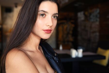 Sexy girl with red lips and piercing eyes close-up with space for text. Model with atmospheric light and lights in the backgroundの写真素材