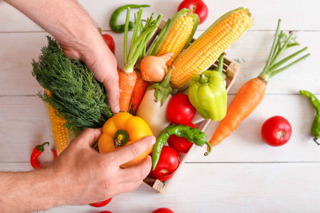 Useful vegetable set for a vegetarian in a box on wooden background top view. Corn, pepper, carrot,...