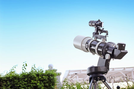 A small telescope is aimed at a bright blue sky. A device for studying stellar space.の写真素材