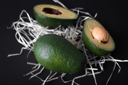 Diet vegan avocado fruit. Halved ripe avocado on a dark background.の写真素材