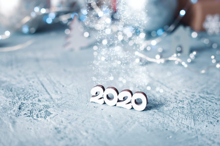 New Year figures 2020 on a blue snowy background with bright lights. Happy New Year card, template,...