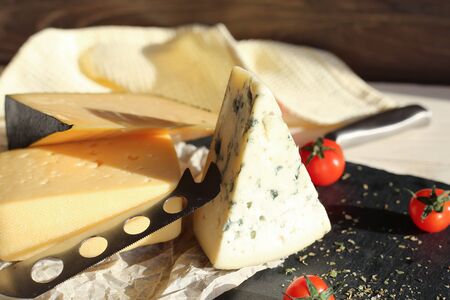 Hard cheese and dorblu cheese on a light wooden surface. Tasty healthy vegan cheeses on the table top viewの写真素材