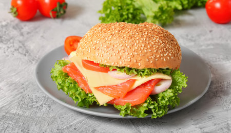 Fishburger of red fish, cheese, onions, tomatoes on a white plate. Vegan fish burger breakfast with...