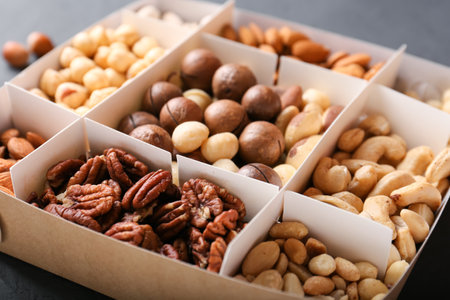 Assorted nuts in a wooden box (from top left: walnut, brazil nut, pecan, pistachios, almond, macadamia, peanut, cashew, hazelnut). Healthy food, nuts as part of the dietの写真素材