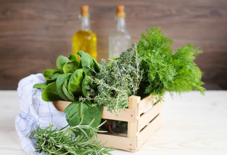 Thyme, dill, rosemary, spinach on a black stone. Bunches of greenery on a white wooden background. Fresh vegetarian organic greens on a tableの写真素材