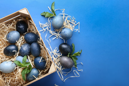 Beautiful blue Easter eggs in the nests on a wooden background. Easter eco festive table decor....