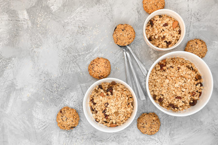 Oats cookies on a gray table in rustic style. seeds, baking in a box with a wooden spoon. Top view