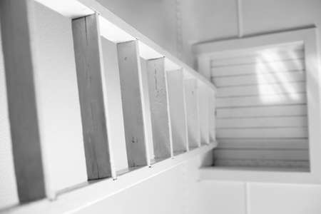 Simple white staircase to a closed attic. The symbol of the only way out of a difficult situation. The solution for a careerist. Stairway to the unknown.の写真素材