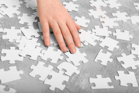 Children's hands collect white puzzles. An educational game for a child.の写真素材