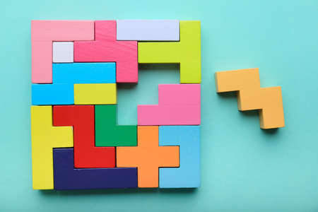 Concept of creative, logical thinking. Different colorful shapes wooden blocks on light background. Geometric shapes in different colors. Child development. Riddle and its solution. Logic tasks top viewの写真素材