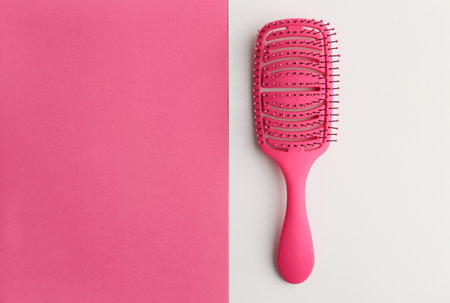 Female hairbrush with place for text. Hairdressing salon business. Hairstyle creation. Hair care, hairdresser tools. Pink background, top view. White pink.の写真素材