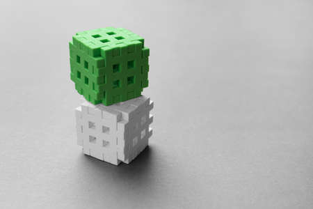White and green, two cubes on a gray background. Place for your text. Leadership concept. Astraction of a 3d cubeの写真素材