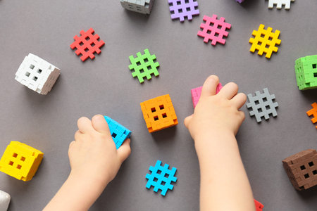 The child builds from a constructor, plays with cubes. Kindergarten. Preschool education, child development concept, color learning. Games for the fine motor skills of the child.の写真素材