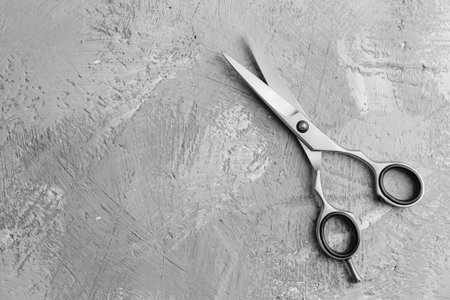 Metal scissors with place for text. Professional salon haircut, hair care. A quality tool. Hairdressing, modern haircuts. Sharp scissors.の写真素材