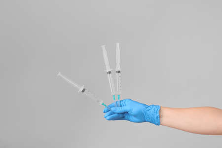 Vaccination concept. Hand in medical gloves and syringes with place for text.の写真素材