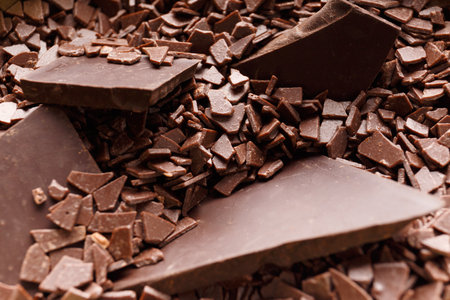 Pieces of broken chocolate in chocolate chips close-up. chocolate background.の写真素材