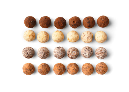 Various types of chocolate truffles on a white background top view. Round sweets made of milk, black and white chocolate on isolation.の写真素材